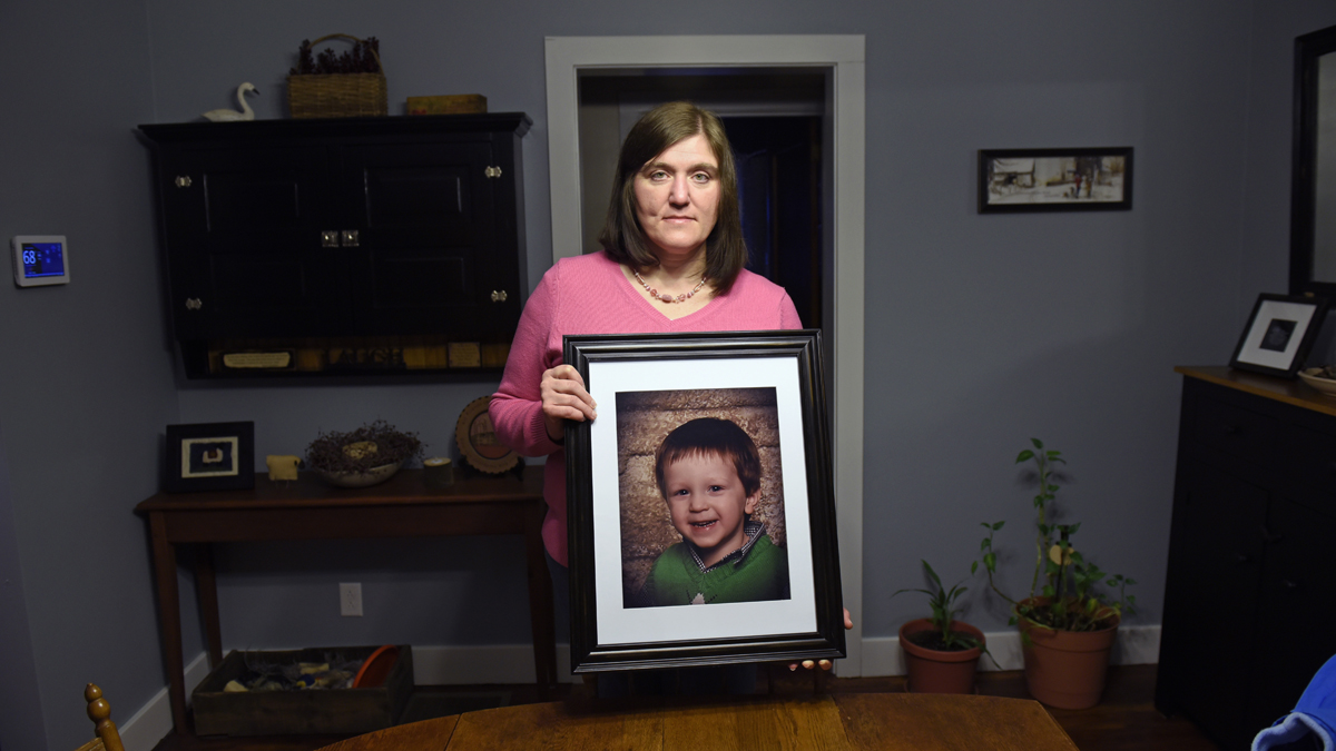 Hollie Ayers poses with a photograph of her late son