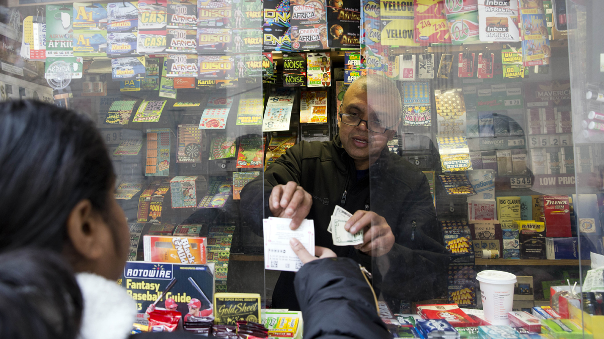 Atul Amin sells Powerball tickets at his news stand in Philadelphia in February. Revenue from jackpot games is about 23 percent below last year's level, according to the Pennsylvania Lottery director.(AP file photo) 
