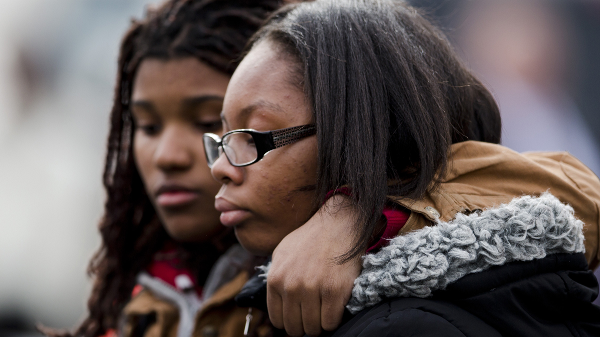  Family members walk ahead of the viewing of slain Philadelphia Police Officer Robert Wilson III on March 13 in Philadelphia.  Wilson was shot and killed after he and his partner exchanged gunfire with two suspects trying to rob a video game store. (Matt Rourke/AP Photo) 
