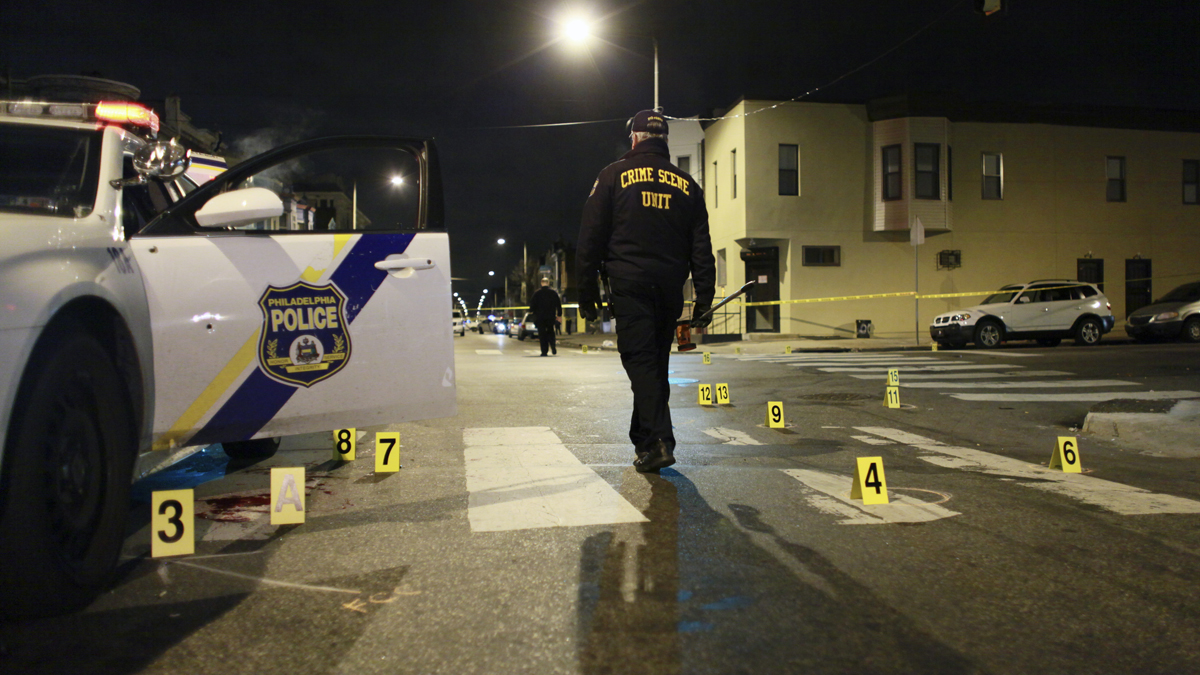  An investigator walks through the scene of a shooting Friday in Philadelphia. A city police officer was shot multiple times by a man who ambushed him as he sat in his marked police cruiser, authorities said. (Joseph Kaczmarek/AP Photo)  
