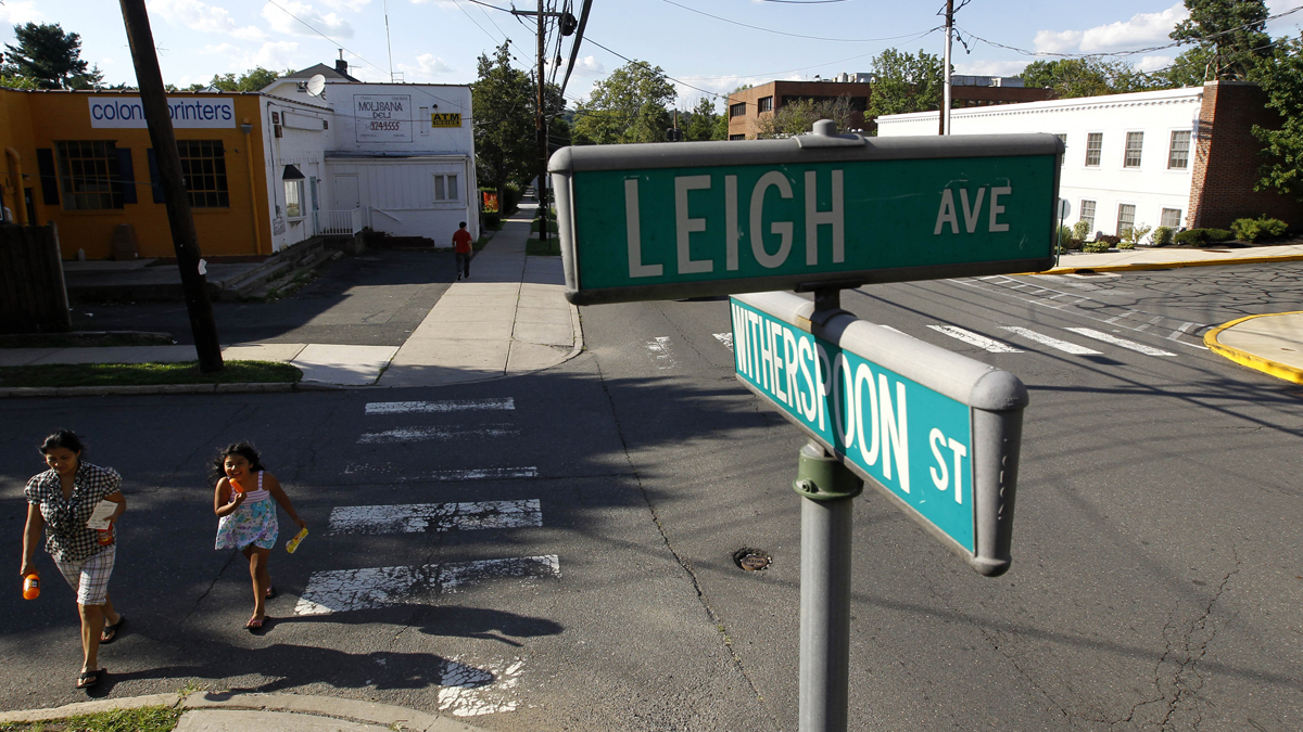  In this Aug. 11, 2011 photo, Rosalia Noyola, left, walks with her daughter Brissa Bautista, 7, near the intersection of Leigh Avenue and Witherspoon Street in Princeton, N.J. According to officials, Leigh Avenue is a good place to see how residents are divided geographically by a diagonal border that separates the Borough of Princeton and Princeton Township. Residents voted to merge. For years, governors have pushed municipal consolidation which shows just how hard it is to get New Jerseyans to make such a change. (AP Photo/Julio Cortez) 