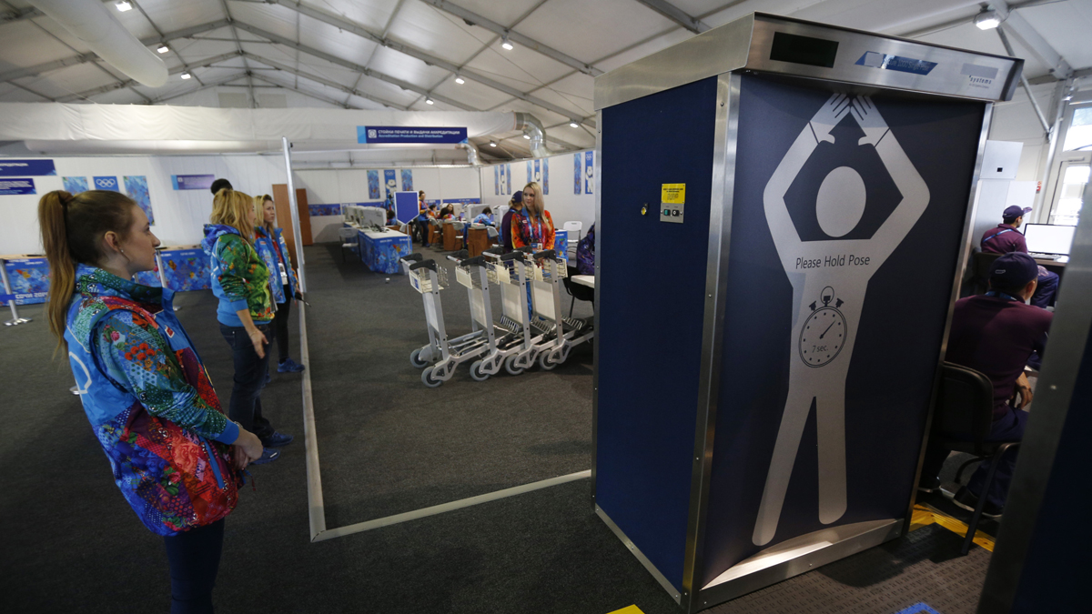 Volunteers wait to go through a security check point at the Coastal Village where athletes will reside during the 2014 Winter Olympics