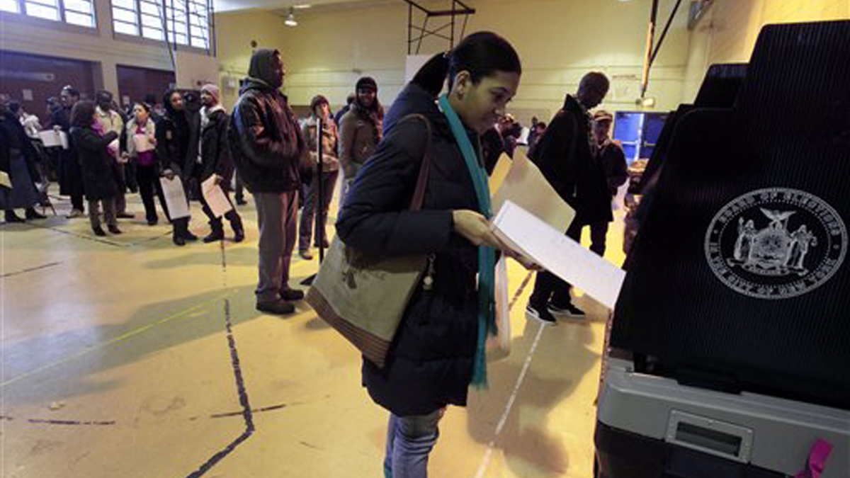 A woman scans her ballot after voting at a school (Richard Drew/AP Photo) 