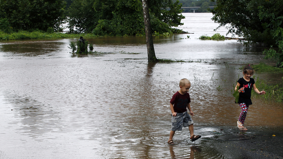  A brother and sister walk in a flooded Delaware Avenue in Yardley, Pa., in August 2011 as the Delaware River overflowed after rains from Hurricane Irene. (Mel Evans/AP Photo) 