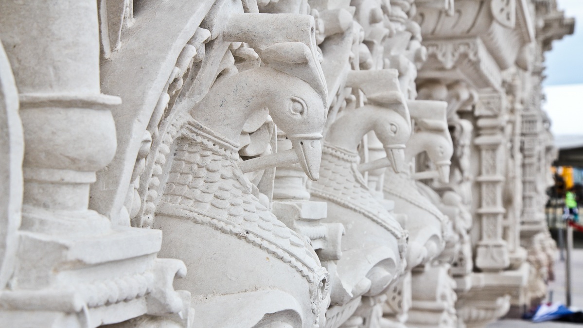 Peacocks are carved out of stone on the 55 foot-tall Mandir building cover. (Kimberly Paynter/WHYY)