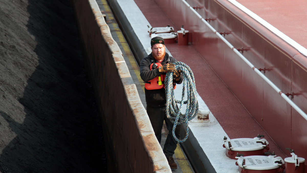 Dustin Frazee works alongside a barge full of coal before he and the rest of the crew of the D.L. Johnson begin moving it east along the Ohio River toward Pittsburgh. (Ryan Loew/For Keystone Crossroads)