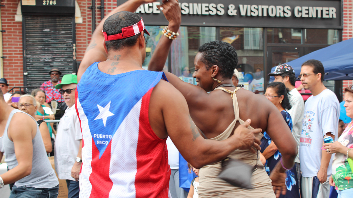 Festival goers dance to the rhythm of the Johnny Cruz Latin Ensemble at the 2013 Nuestro Barrio Fair.  (Elisabeth Perez Luna/WHYY) 