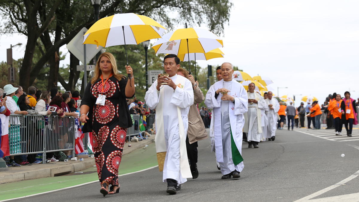  Priests helped Pope Francis administer Communion to thousands of Catholics who attended Mass on the Benjamin Franklin Parkway, Sunday, Sept. 27, 2015. (Lindsay Lazarski/WHYY) 