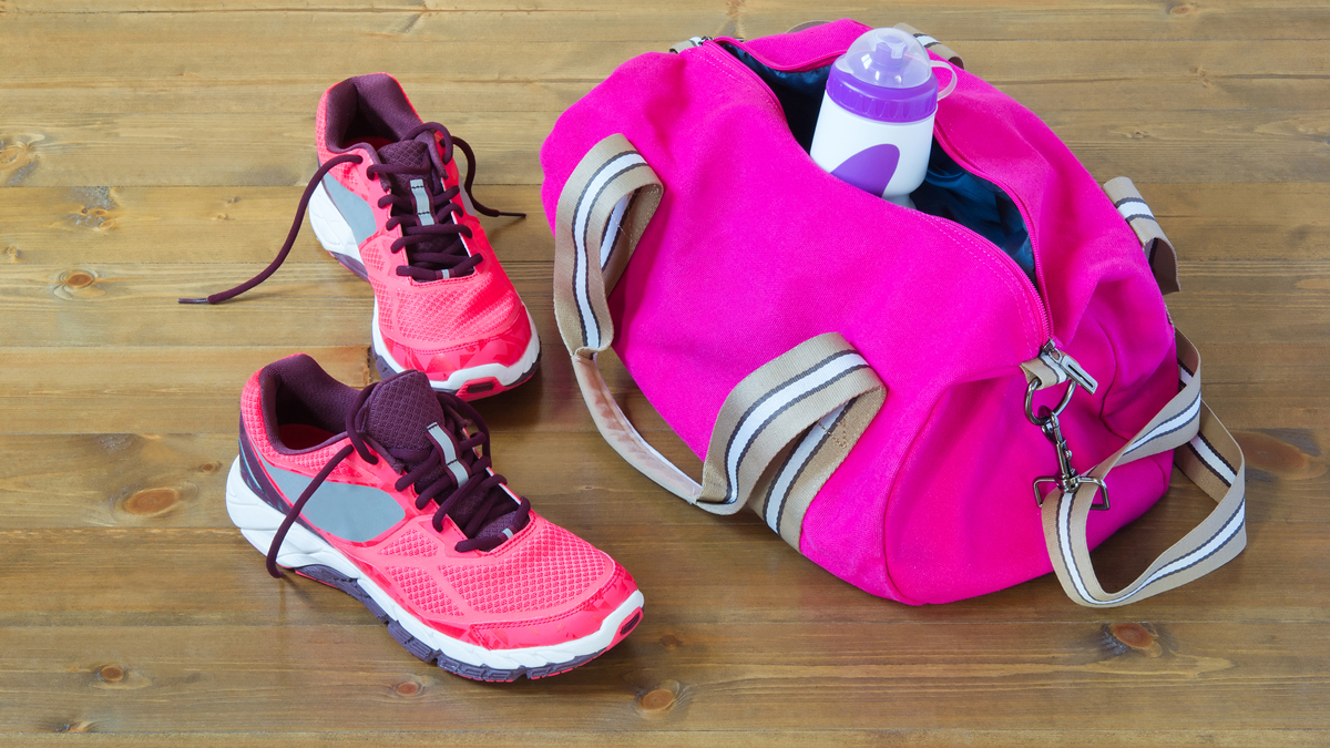 (Aleksei128/<a href='http://www.bigstockphoto.com/image-142649240/stock-photo-bag-for-sporting-on-the-floor%2C-on-a-dark-tree'>Big Stock Photo</a>)