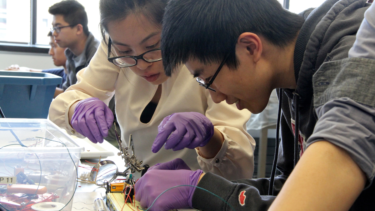 Stephanie Mark and her lab mate maneuvering the severed cockroach leg into position. (Emma Lee/WHYY)