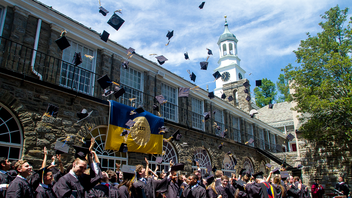 The graduating class toss their hats at the end of the ceremony. (Brad Larrison/for NewsWorks)