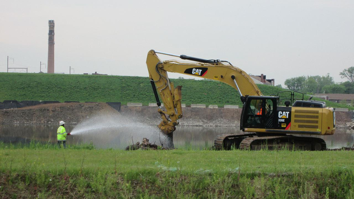  Contractors remove stumps and debris along the berm of the pond at the BoRit Asbestos site in Ambler, Pa. (Image courtesy of OSC/United States Environmental Protection Agency) 