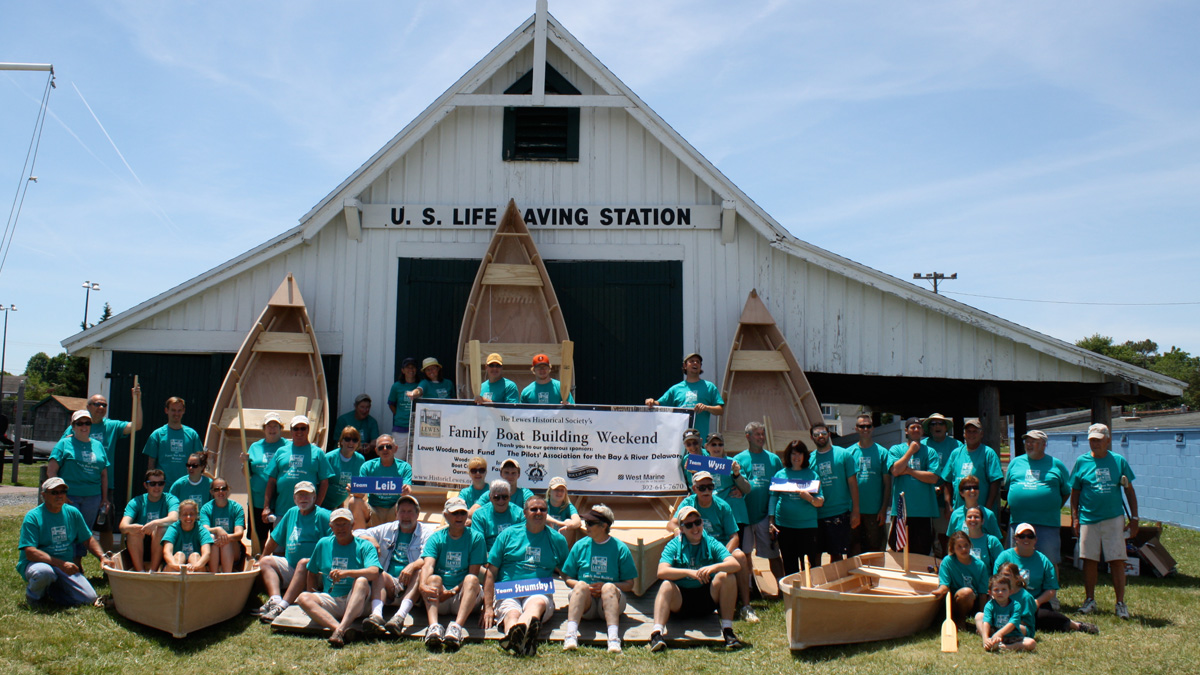  Members of the 2014 boat building groups with their completed vessels. 