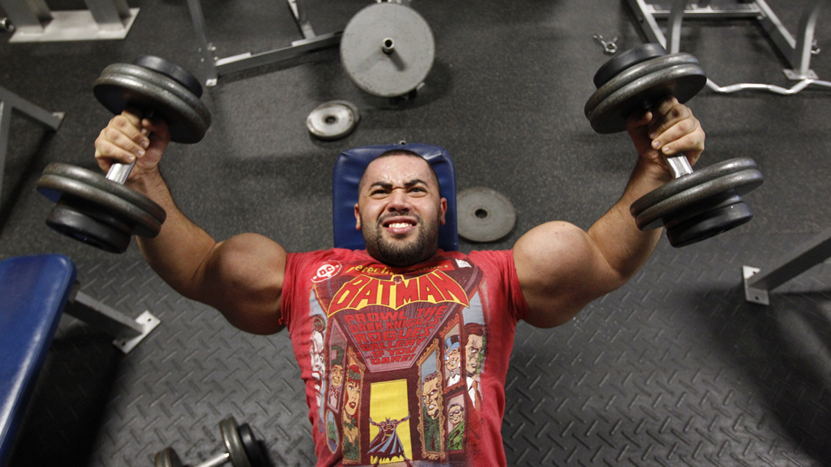 Body builder Moustafa Ismail lifts weights during his daily workout. Ismail has been given the title of world's biggest arms