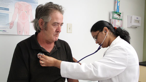 Dr. Madhumathi Gunasekarn examines John Pike at the Northgate II clinic in Camden. Pike is one of about 100 residents of the apartment complex who have visited the medical office. (Emma Lee/for NewsWorks)