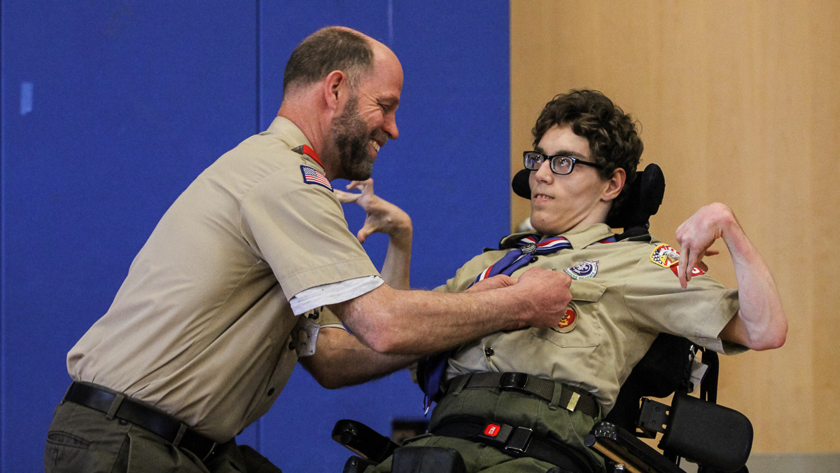  Bob Matcovich pins Christian's new honors onto his son's uniform. (Kimberly Paynter/WHYY) 