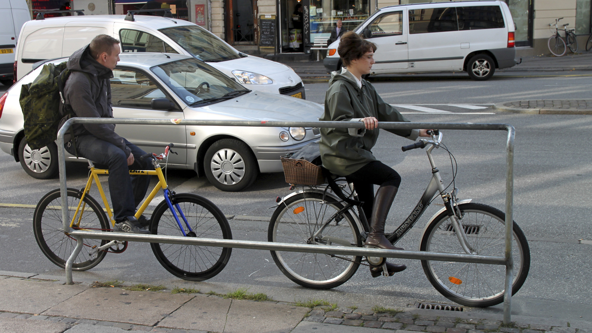  Two cyclists use a foot rest with handles at a major intersection on a downtown Copenhagen street with bicycle-friendly features. (AP Photo/Jan M. Olsen) 