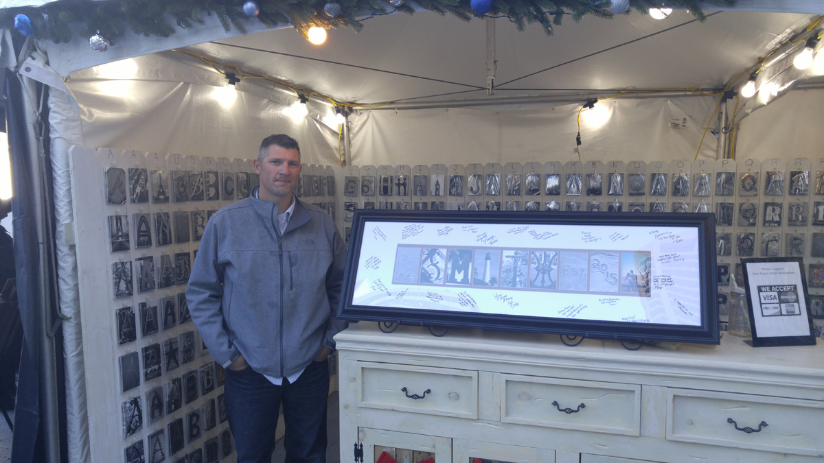 Dana Brogan, who set up his stand with photos, said it's an opportunity to expand his business based in Lahaska and test market in the city. (Tom MacDonald/WHYY) 