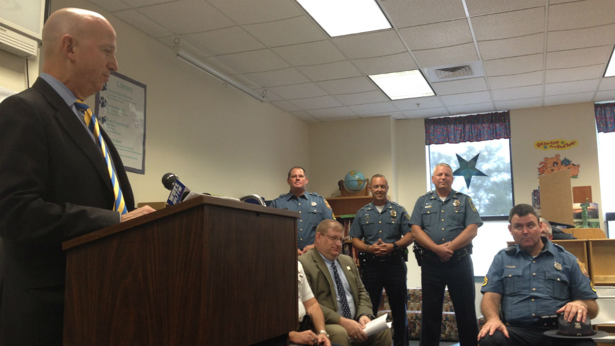  Governor Jack Markell (far left) speaks at Richey Elementary School while local troopers look on. (Avi Wolfman-Arent/ WHYY) 