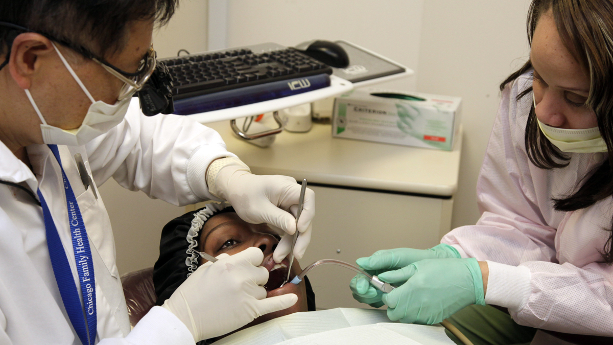  A dentist and his assistant attend to a patient. (AP Photo/M. Spencer Green, file) 
