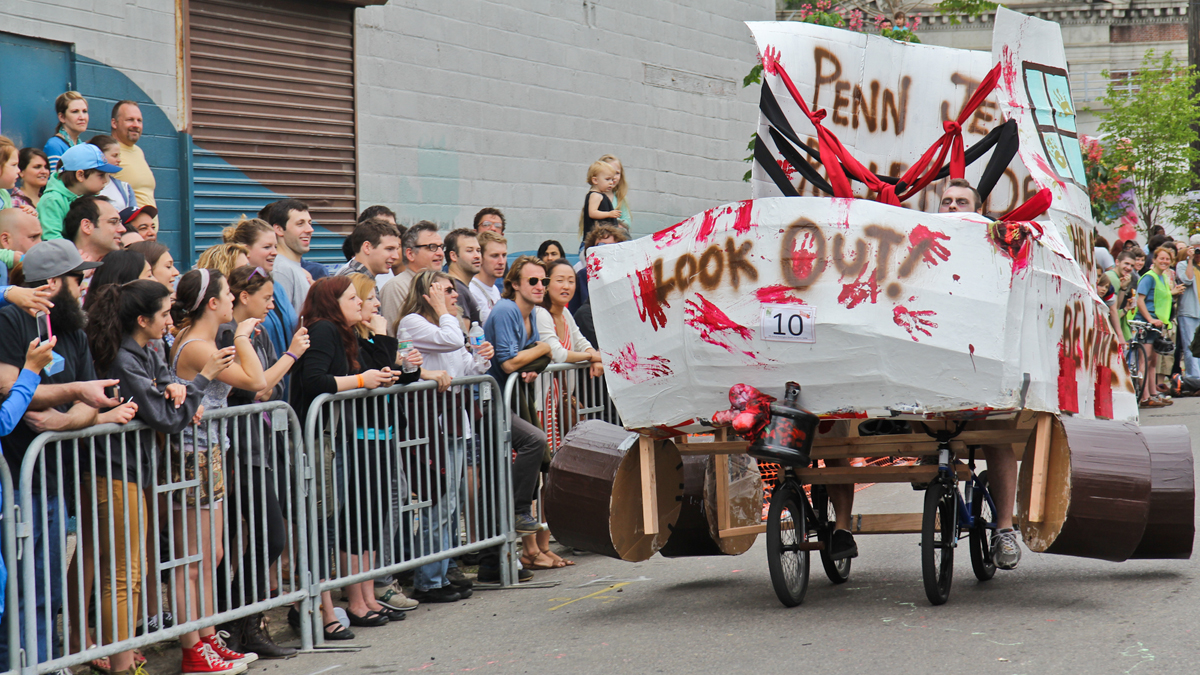  First time Kensington Kinetic Sculpture Derby participants from the Penn Jersey Roller Derby League barrel towards a mud in their zombie skate creation. (Kimberly Paynter/WHYY) 