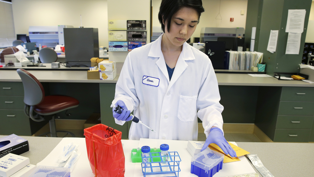  A forensic scientist extracts DNA from samples. (AP Photo/Ted S. Warren) 