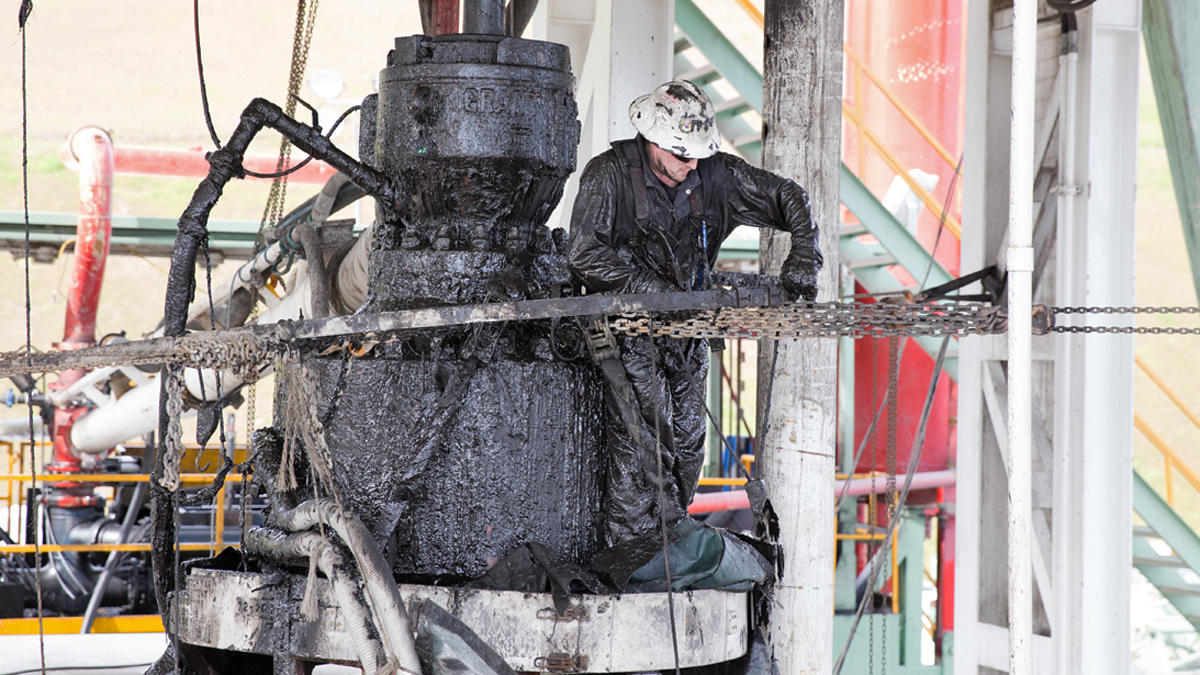 A drill worker covered in mud