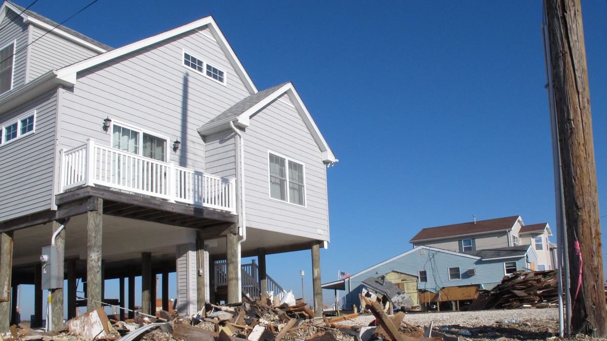  The home on the left, in Tuckerton, N.J., emerged from Superstorm Sandy intact because it was elevated. (AP Photo/Wayne Parry) 