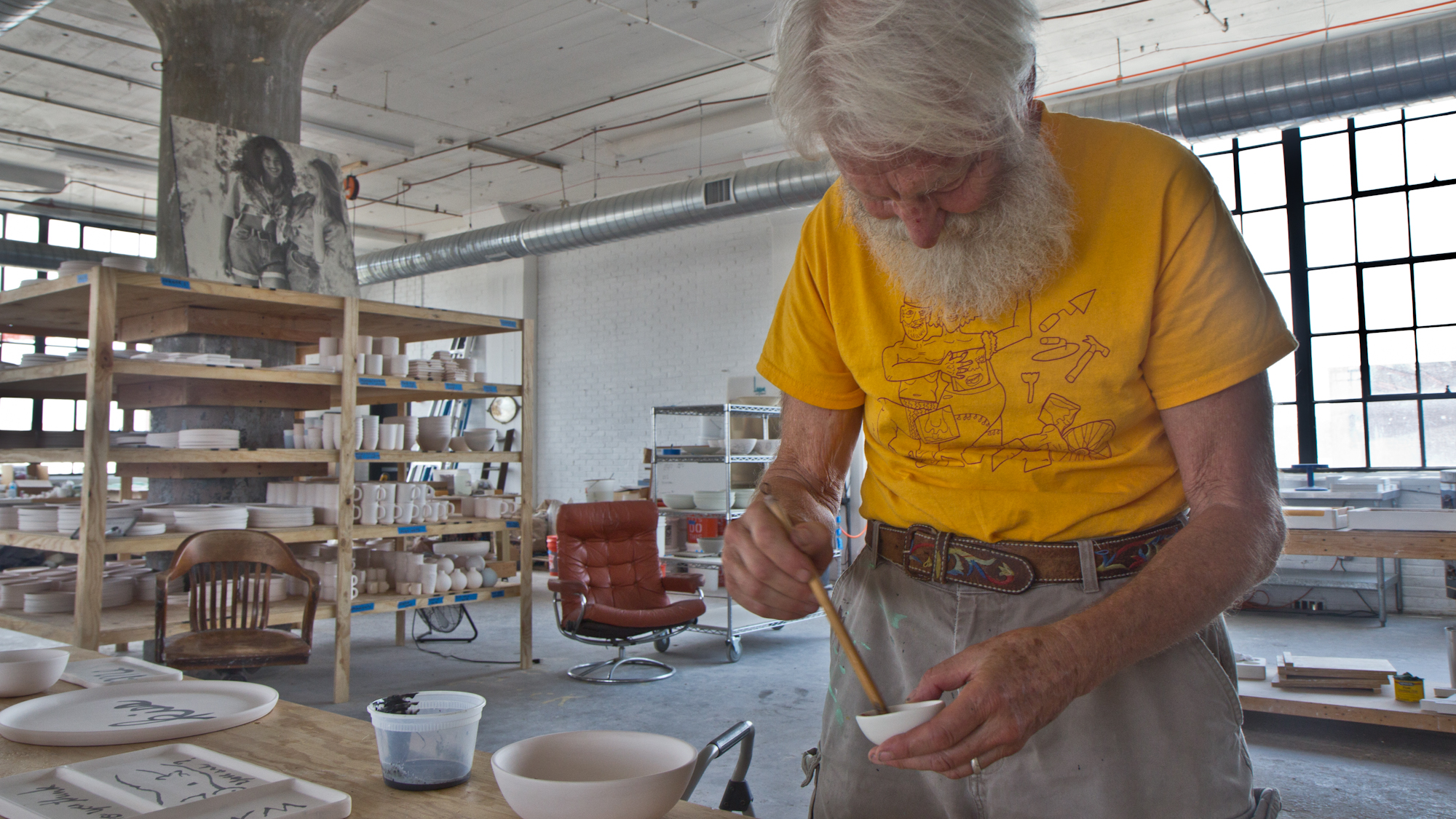 Famed Philadelphia artist Isaiah Zagar paints on the products of Felt+Fat, a new custom dishware company based in Philadelphia’s Kensington neighborhood. (Kimberly Paynter/WHYY)