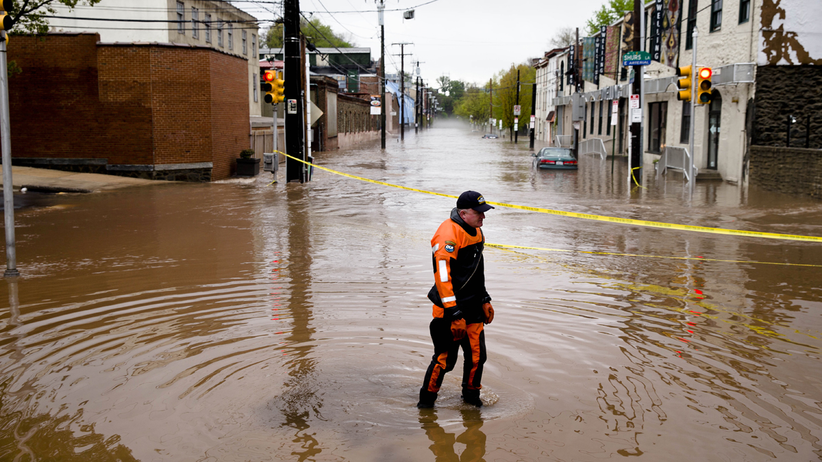 Marine unit police officer Robert Jonah walks through flood waters from the Schuylkill River on Main Street in the Manayunk neighborhood of Philadelphia on May 1