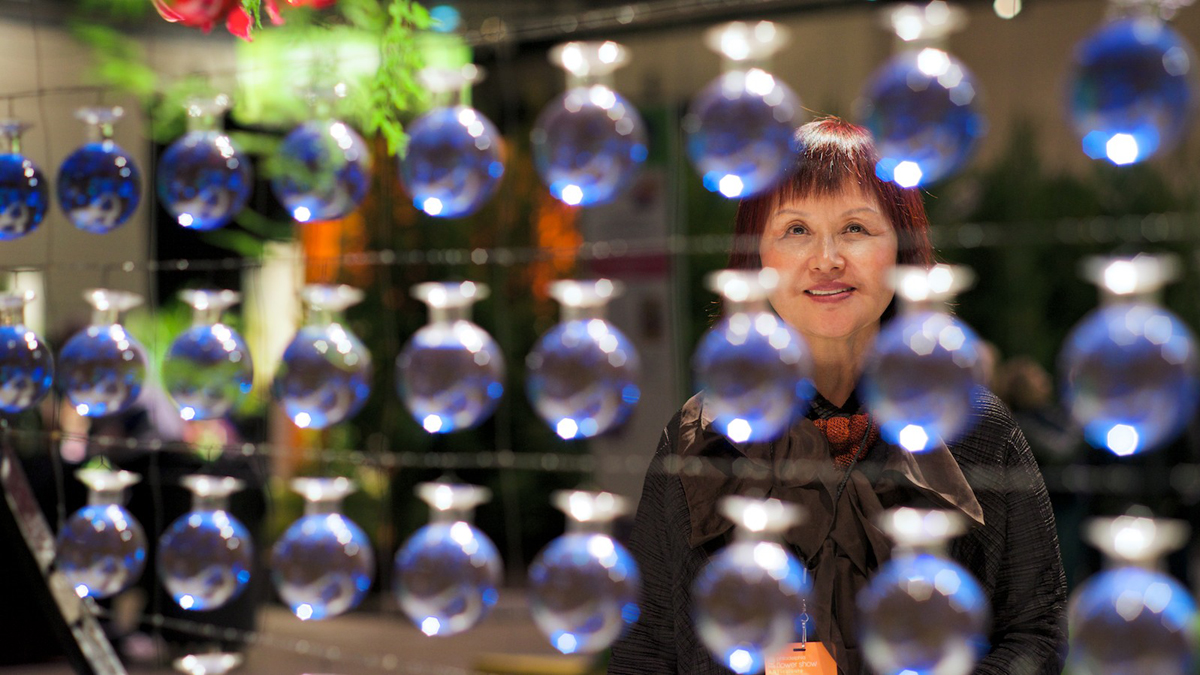  Floral Designer Claire Wong Kang stands behind her work titled Global Dancers. The work is resembling the Ying Yang symbol of the Korean Flag, she said. (Bas Slabbers/for NewsWorks) 