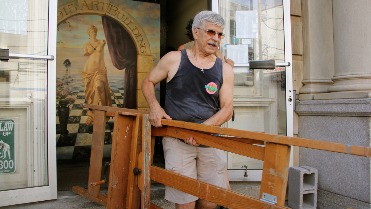 Giuseppe Riviera takes what he needs from his studio at 915 Art Building. The building, which provides studio space to 100 artists, was closed because of fire code violations. (Emma Lee/WHYY)