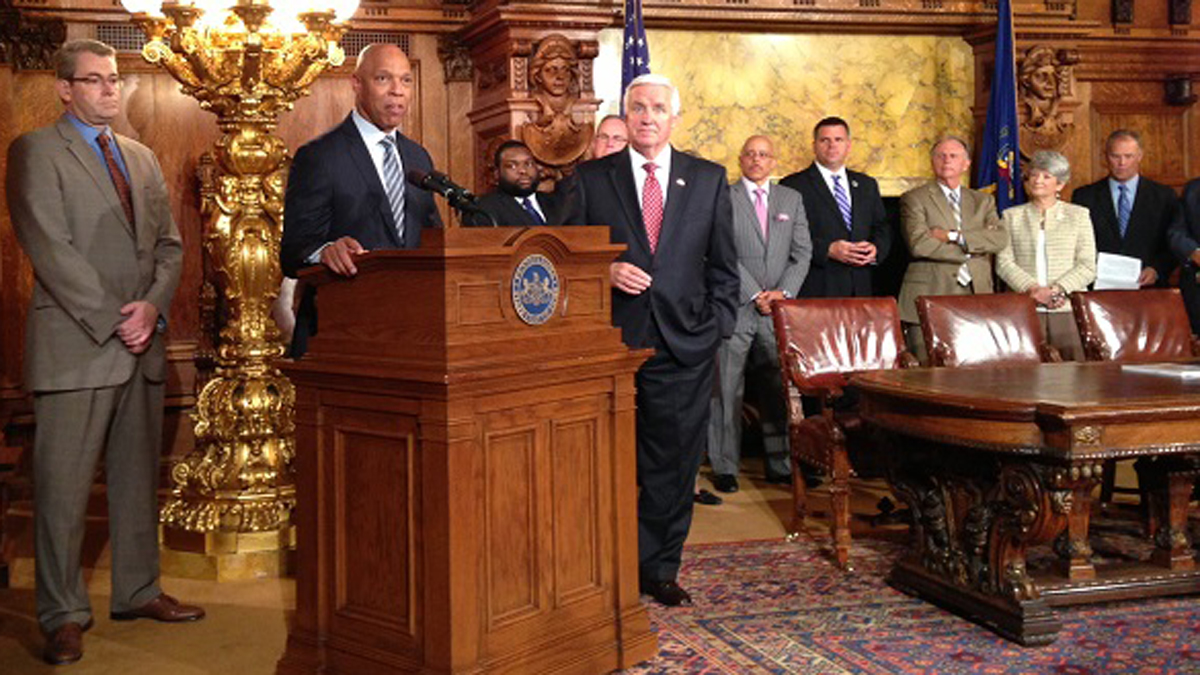  Flanked by Gov. Tom Corbett, right, and School Reform Commission Chairman Bill Green, Philadelphia School District Superintendent William Hite expresses his elation after the governor signed the Philadelphia cigarette tax bill into law Wednesday. (Mary Wilson/WHYY) 