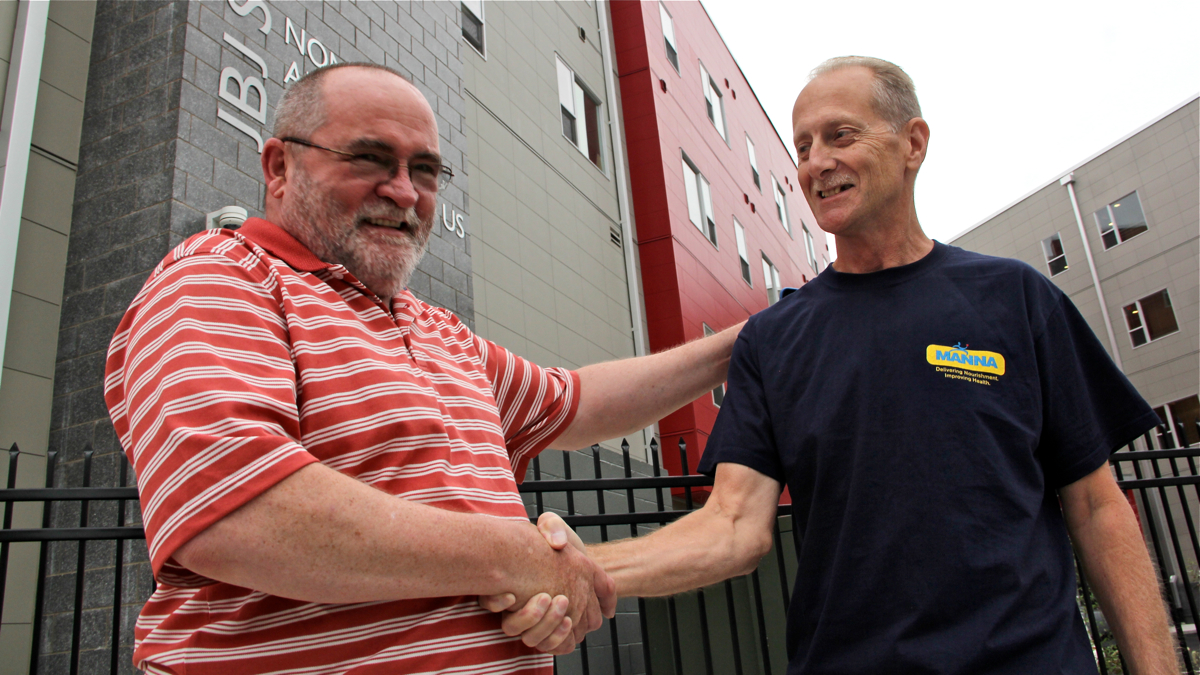  Bob Long (right) shakes hands with Earl Driscoll, the social worker who helped him find his way home. (Emma Lee/for NewsWorks)  