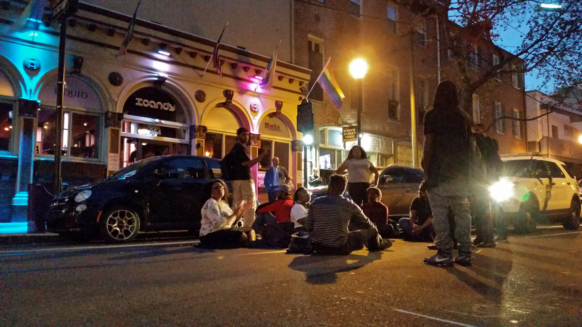 A small group protests racism in the Gayborhood by shutting down the street in front of ICandy. (Peter Crimmins/WHYY)