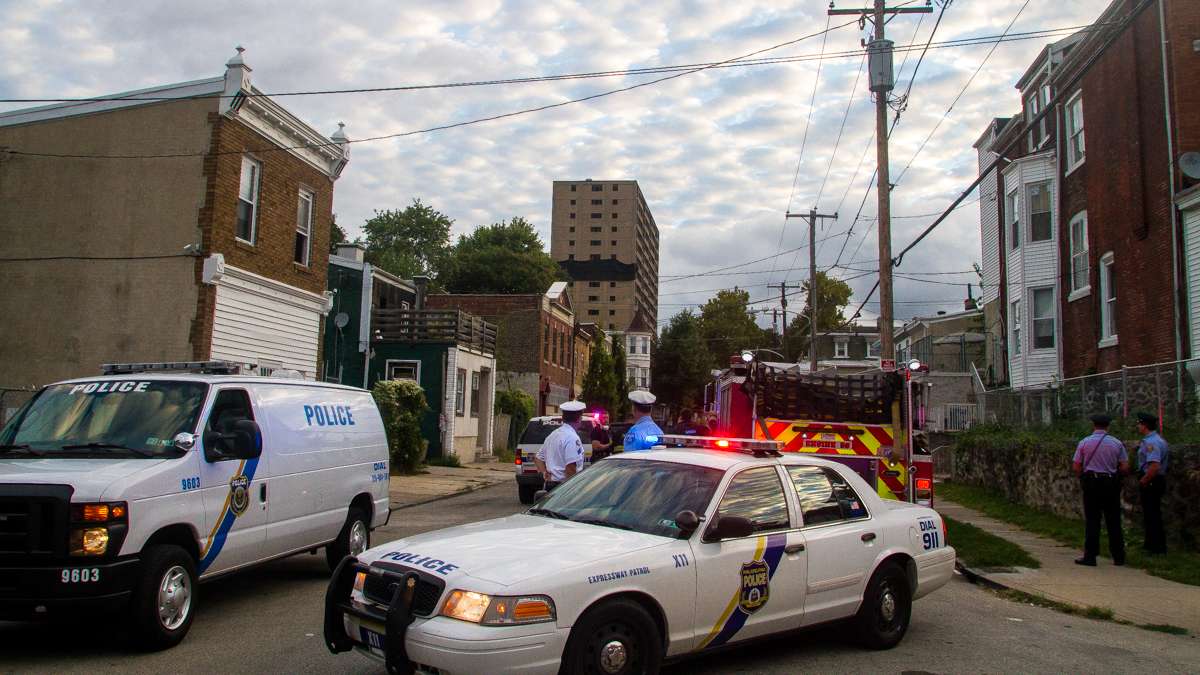  Off in the distance, the Queen Lane Apartments tower stands in the waning moments of its existence. (Brad Larrison/for NewsWorks) 