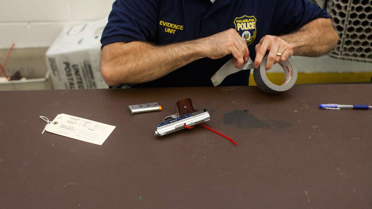 A handgun is outfitted with a gun lock at buyback event in West Oak Lane. (Brad Larrison for WHYY)