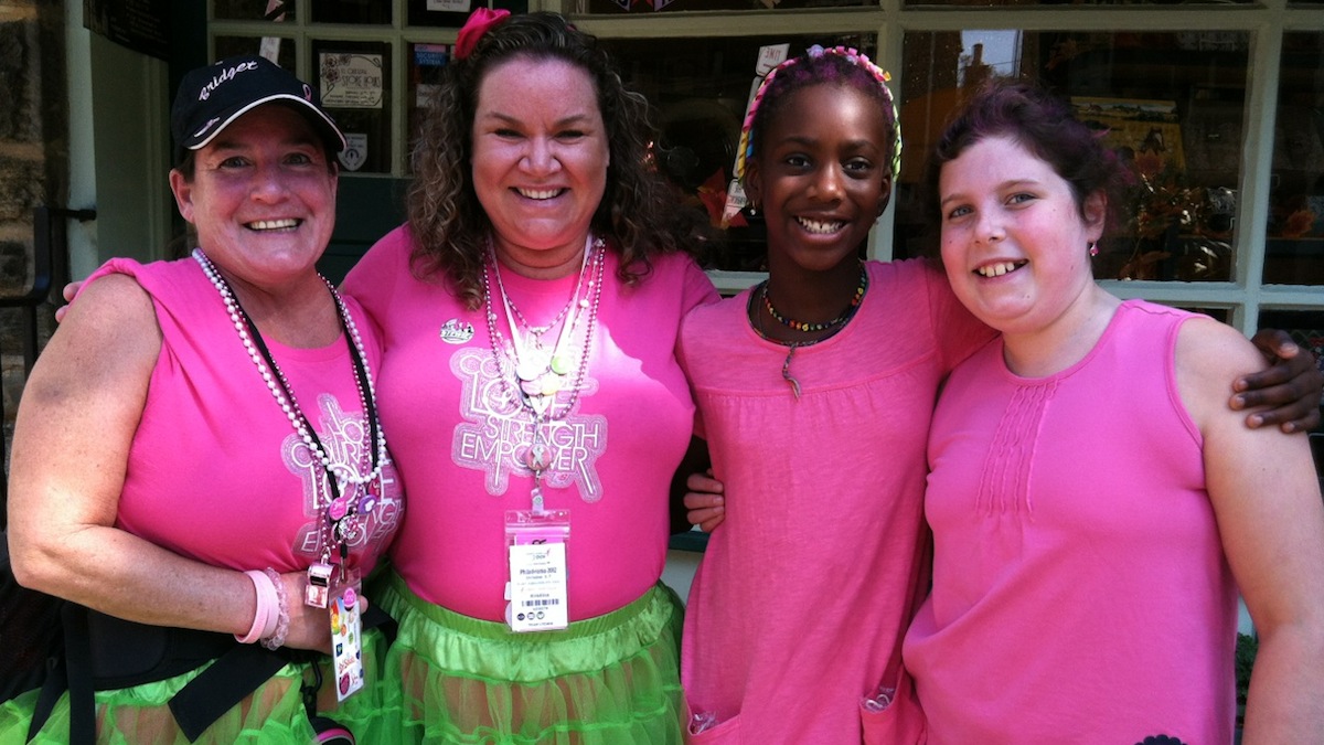  Walkers Bridget Rose and Kristina Wesselink pose with cheerers Maya Gerlach and Annika Forsthoefel at the Chestnut Hill cheering station last October. (Jen Bradley/for NewsWorks) 