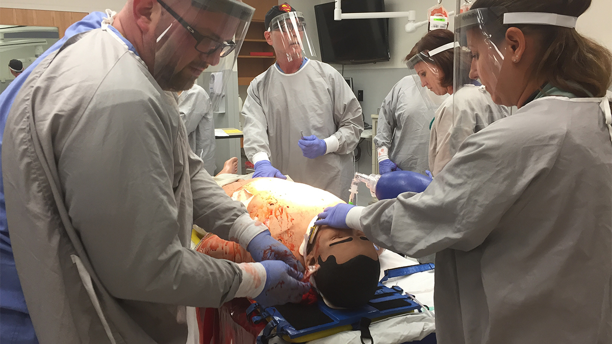 Christiana Hospital staffers recreate a real gunshot case for high school students. (Maiken Scott/WHYY)