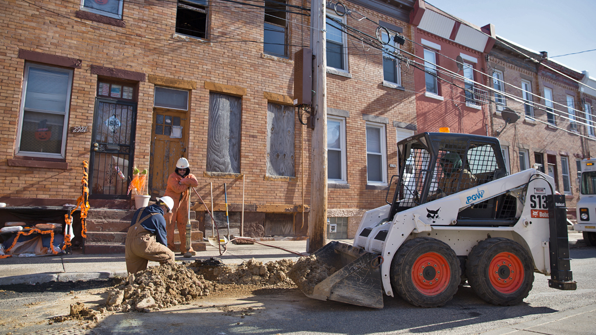  A Philadelphia Gas Works crew back fills part of Van Pelt Street after replacing aging gas lines in North Philadelphia. (Lindsay Lazarski/WHYY) 