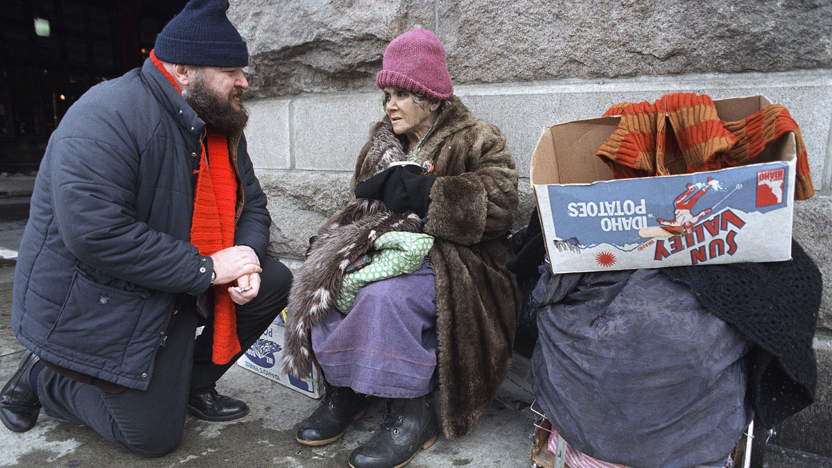  A man stops to talk to a homeless woman outside of Reading Terminal Market in Philadelphia.  (AP Photo/Charles Krupa, file) 