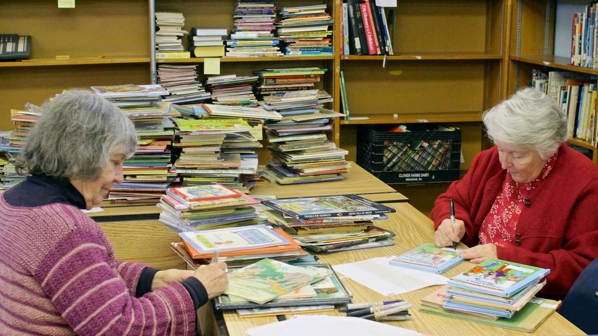  Neighborhood volunteers from Mutual Mt. Airy and the local town watch help sort, classify and label incoming book donations. (Jana Shea/for NewsWorks) 