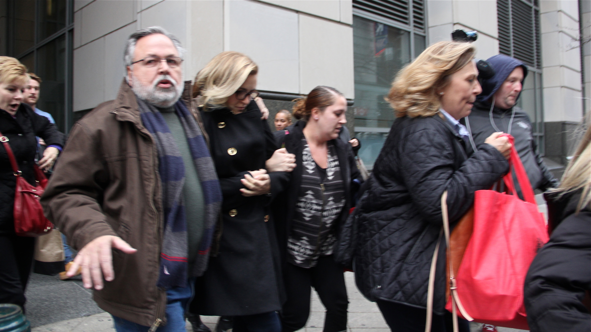 Supporters of Kathryn Knott hustle her from the courthouse after she was convicted of assault for her role in the beating of a gay couple in Center City.  (Emma Lee/WHYY)