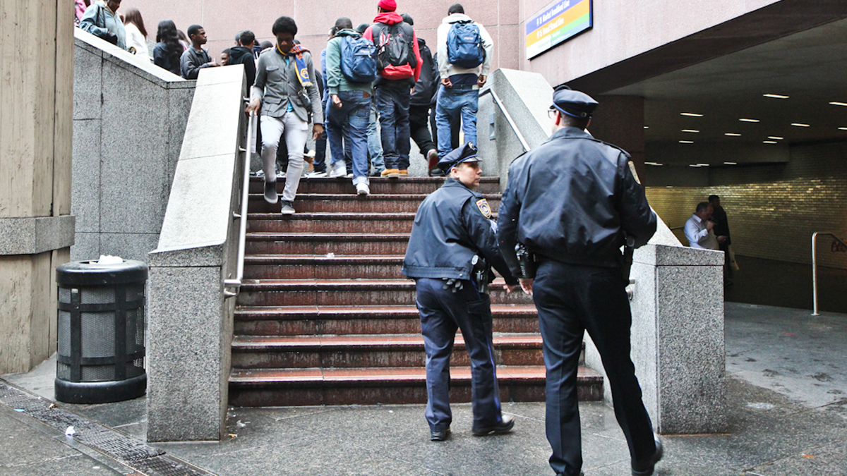 SEPTA Police watch Philadelphia students as they exit a subway concourse in Center City. (Kimberly Paynter/WHYY) 