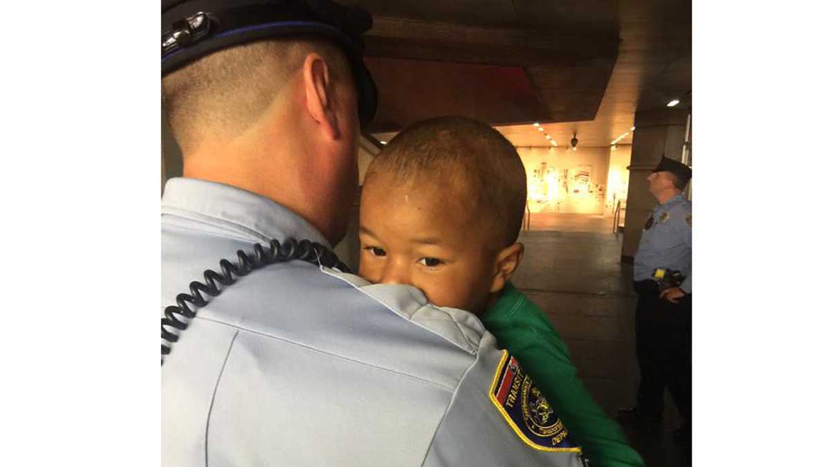  A SEPTA officer carries the child found wandering in LOVE Park Friday night. (Photo by Bill Newbold)  