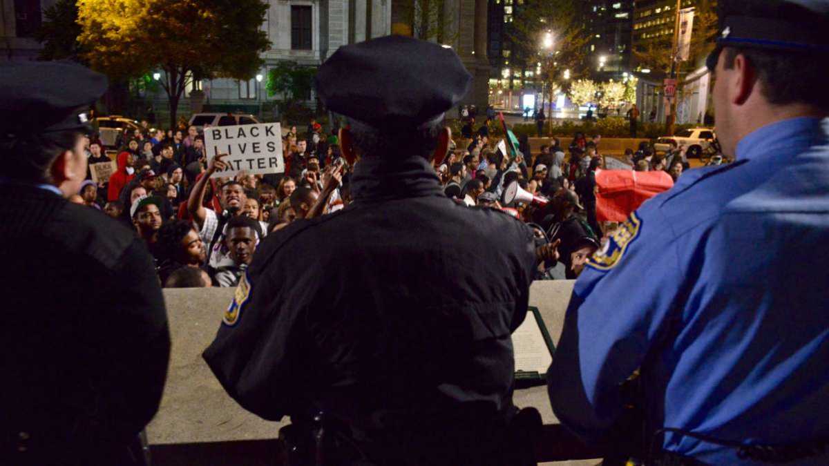  Police officers watch as protesters pass by Philadelphia's City Hall in May. (Bastiaan Slabbers/for NewsWorks, file) 