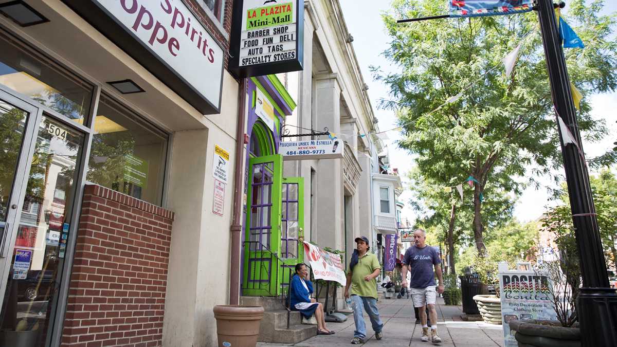  Peatones  se pasear en la calle  West Marshall en la parte Latina en Norristown, Pa. La colaboración entre la policia de Norristown y las autoridades federales de inmigración han provocado un número de deportaciones de residentes. (Lindsay Lazarski/WHYY) 