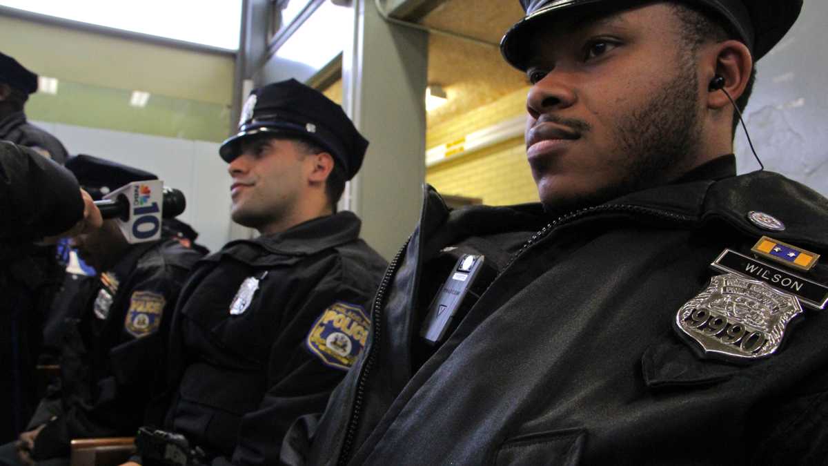 Philadelphia Police Officer Robert Wilson III (right) died after he was shot in the head at a GameStop in North Philadelphia on March 5. (Emma Lee/WHYY) 