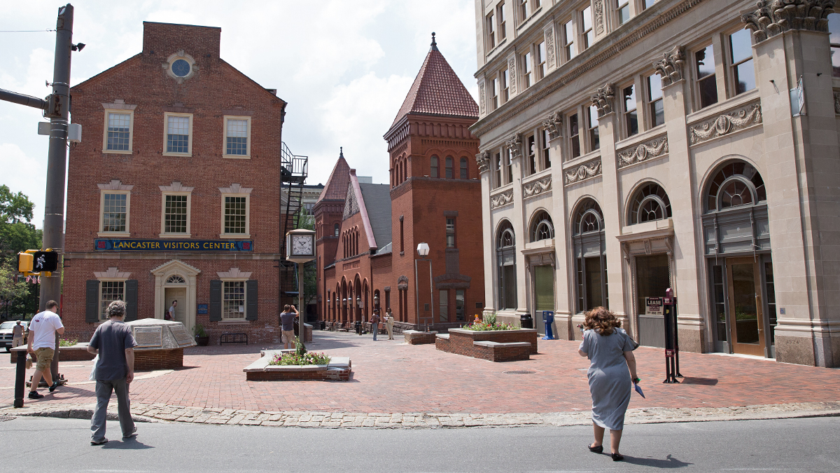 Pedestrians walk toward the downtown visitors center and Central Market in Lancaster, Pennsylvania. (Lindsay Lazarski/WHYY)
