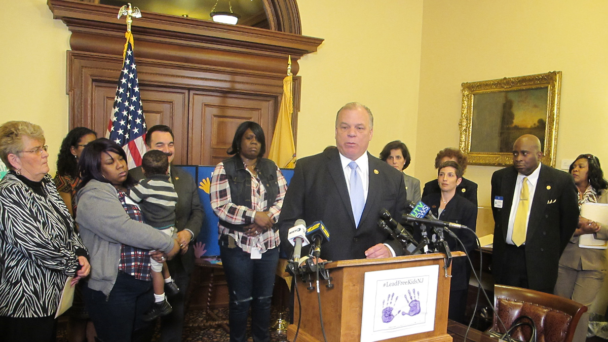 Surrounded by advocates for lead-remediation efforts